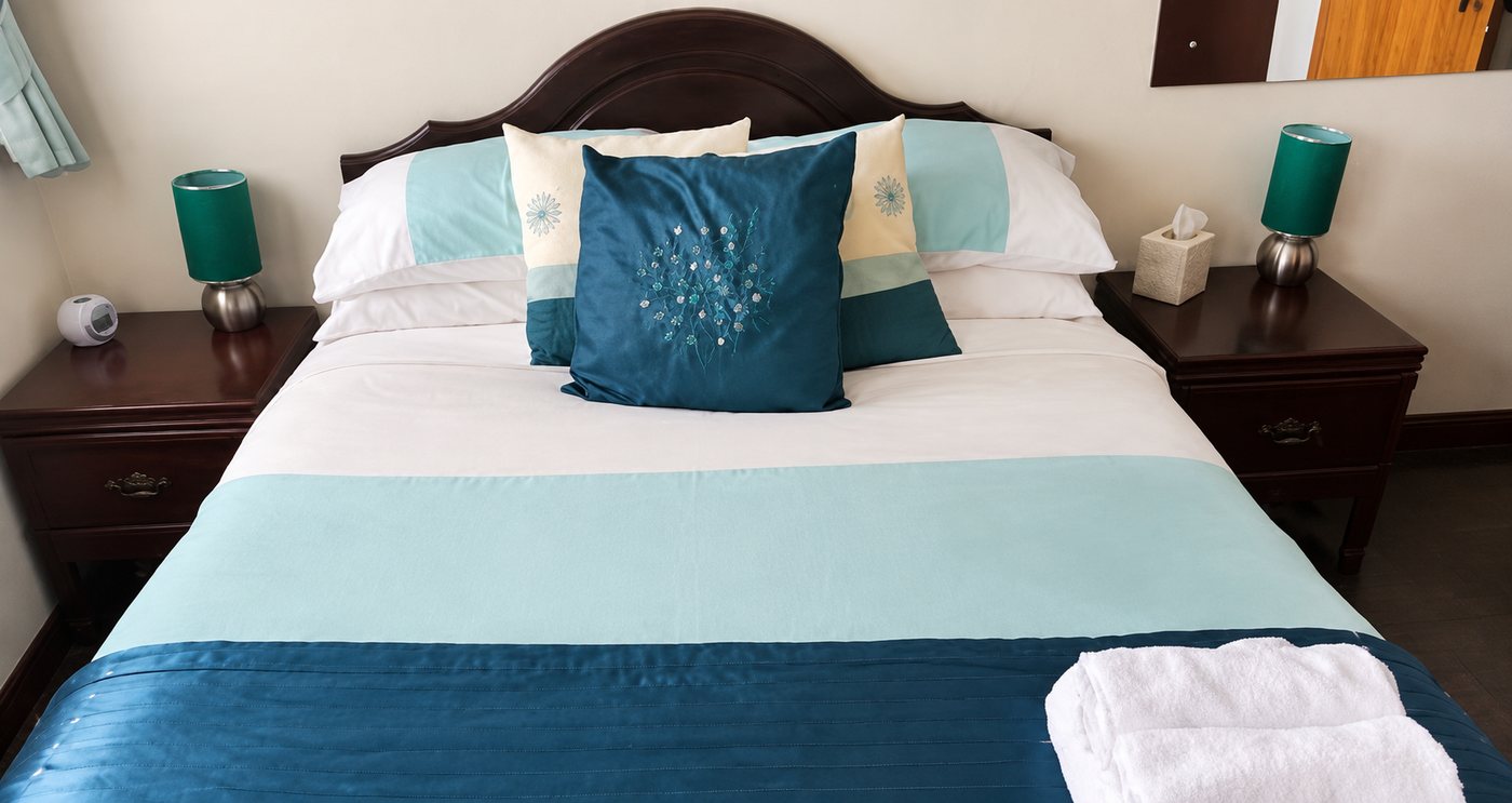 Double bedroom with teal bedding at Woods End Guest House