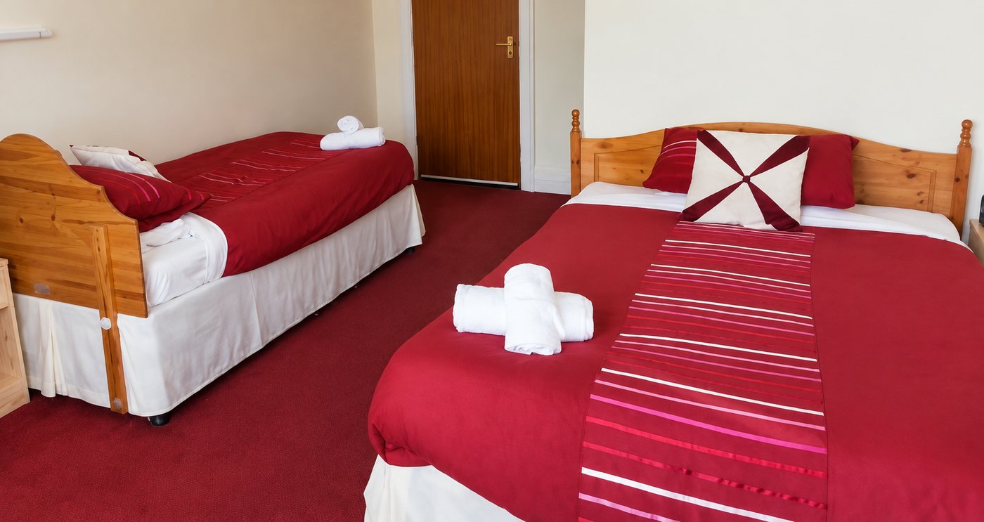 Flexible family room with red bedding at Woods End Guest House